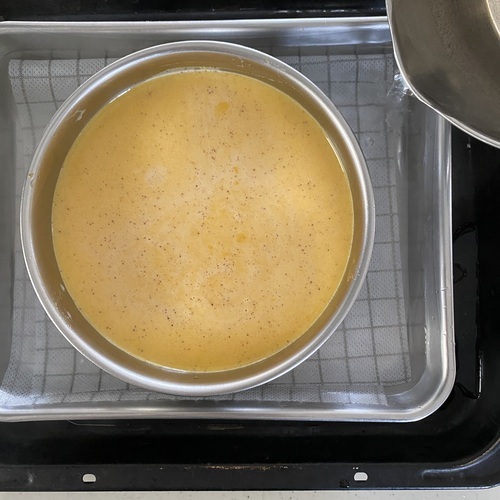 バットに薄手の布巾を敷き④をのせる。
プリン液の高さまで湯（70℃前後）を注ぎ、140℃に余熱したオーブンで約40分湯煎焼きする。