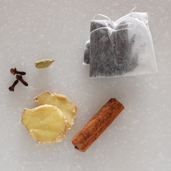カルダモンは実を開き、シナモンスティック、クローブ、しょうがスライスと一緒にお茶パックに入れる。