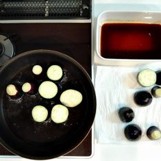 茄子の水気をペーパーでしっかりと抜き、170℃くらいの油で茄子が軟らかくなるまで揚げる（菜箸がすっと通るまで）。揚げあがったらそのまますぐに③の煮汁の中に並べていく。