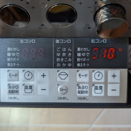 コンロにフライパンを置いて点火し、焼サポートを設定し、タイマーを10分に設定する。