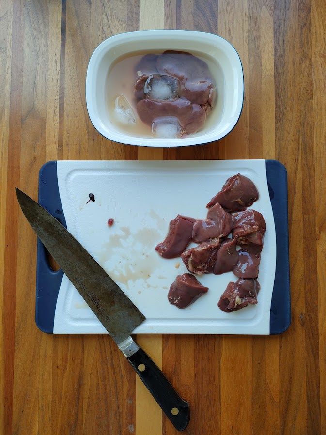 鶏レバーは冷水に5分ほど漬け、漬けながら一口大に切り、中に残っている血液を丁寧に取り除く。冷水を何度か変えながら、やさしくかき混ぜ、水が透明になるまで繰り返す。