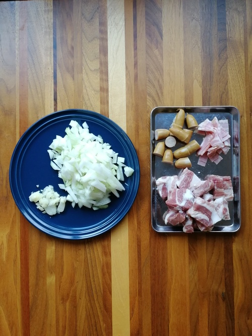 玉ねぎとにんにくは粗みじんに切る。豚肉は2×3㎝の大きさに切って、塩（小さじ1/2）を揉みこむ。ソーセージは2㎝に小口切り。ベーコンは1cｍ幅に切る。