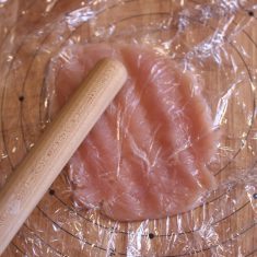ささみは薄皮と筋を取ったら両面ラップに包んで瓶底で叩いて薄くのばす。
