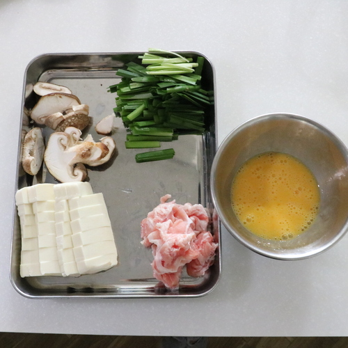 豚バラ薄切り肉は食べやすい大きさに、ニラは4㎝の長さに切る。しいたけは薄切りにする。絹ごし豆腐は1㎝幅の棒状に切る。卵は溶いておく。
