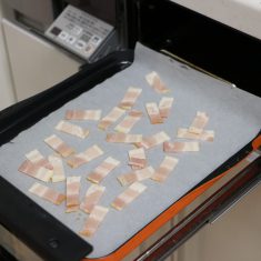ベーコンは7㎜程の幅に切り、オーブンシートを敷いたマルチグリルプレートに乗せ、調理モード［焼く］火加減・中で6~7分間加熱し、カリカリになったらキッチンペーパーに取り脂分を取り除く。