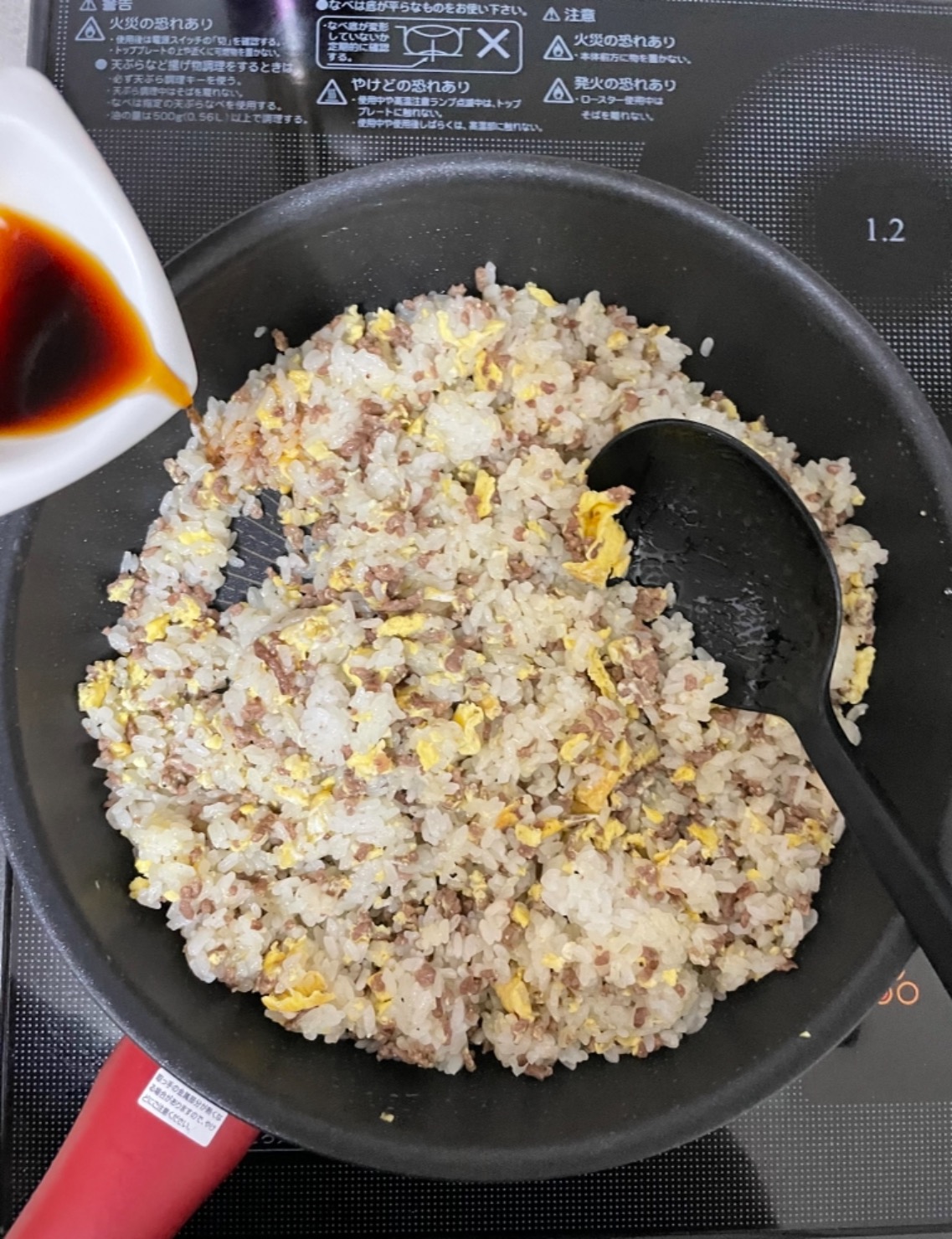 ごはん全体的に火が通ったら味の素、酒、醤油を入れ、再び炒める。