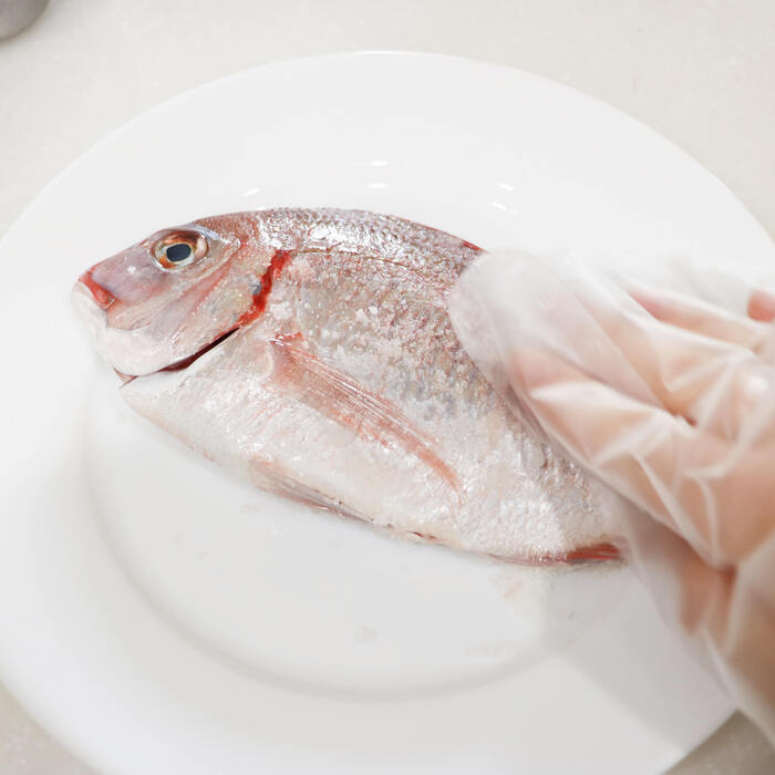 ＝調理＝
ミニトマトはヘタを取って半分に切る。
にんにくは包丁の腹でつぶす。
鯛の両面に塩をすりこむ。