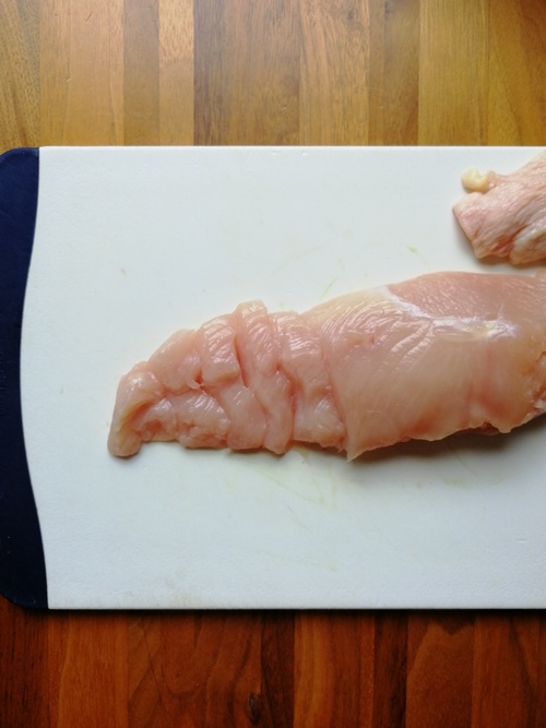 鶏むね肉は、皮と余分な脂肪を取り除き、身の作りに沿って縦に２等分にする。繊維方向を良く見て、繊維を断ち切るように７㎜幅くらいにそぎ切りにする。