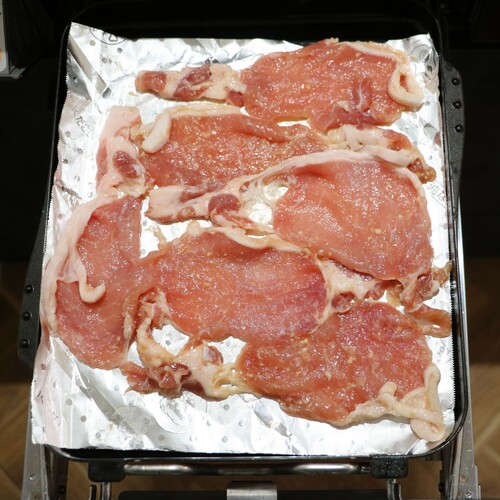 マルチグリルのプレートパンにくっつかないアルミを敷き、その上に漬け込んだ豚肉を広げて並べる。調理モード［焼く］の中火で10分加熱したら出来上がり。