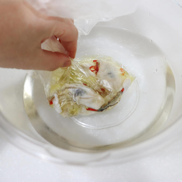 牡蠣はきれいに洗い、水気を切る。=A=と牡蠣をポリ袋に入れ、袋を水の入ったボウルに漬けて袋の空気をしっかり抜く。