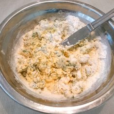 ふるった薄力粉を入れ、ざっくり切り込むように混ぜる。ケーキの生地ができたらパウンドケーキ型に入れ、型を４～５回軽く叩いて空気を抜く。