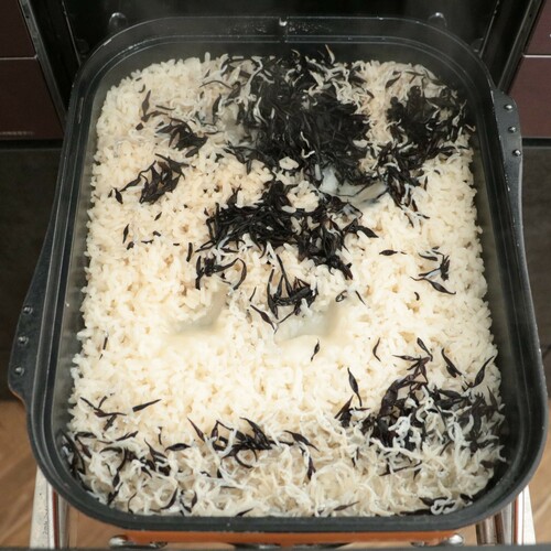 マルチグリルのキャセロールに米、餅、じゃこ、水を切ったひじき、白だし、水を入れて蓋をし、オートメニュー[ごはん]で加熱する。