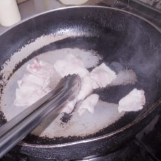 豚ばら肉を食べやすい大きさに切り、油で炒める。