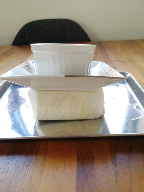 豆腐はペーパータオルで包み、重しをして30分おき、しっかり水切りする。