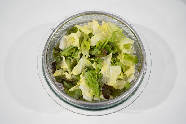 白菜とサニーレタスを手で食べやすいサイズにちぎり、冷水に浸す。いちごを薄切りにする。