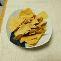 チップスをおたまの背で軽く砕き、スープを馴染ませる
