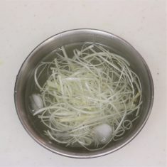 しょうがは2/3ほどを薄切りにしておく。ねぎの白い部分は残りのしょうがとともに細切りにして氷水に離しておく。豆苗は洗って半分の長さに切っておく。