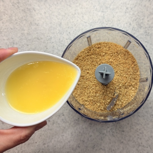 フードプロセッサーにクラッカーを入れ粉砕する。
溶かしバターを入れ、再度良く混ぜる。