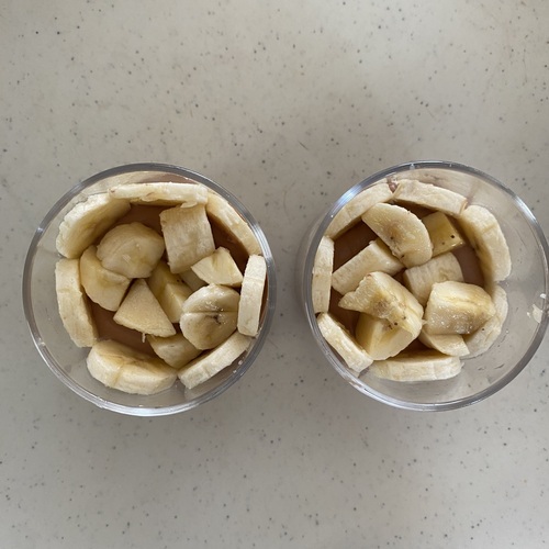 グラス合わせてスポンジケーキを1/4ずつ敷き込む。その上にチョコレートクリームをのせ、グラスに沿って輪切りバナナ、中央には角切りバナナをのせる。
