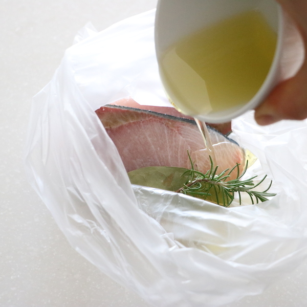 にんにくは包丁の腹でつぶす。ぶりに塩をしっかりすりこむ。すべての材料を耐熱のポリ袋に入れ、袋の中の空気を抜き、口を縛る。
