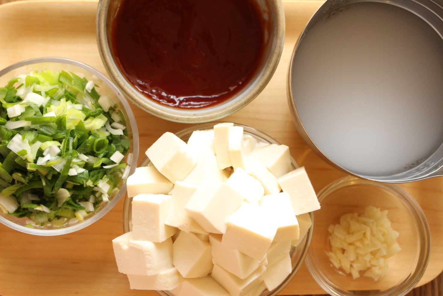 豆腐は２cmの角切りにし、長ねぎとニンニクはみじん切りにする。片栗粉は水で溶き、ケチャップ・ソース・醤油・ラー油を合わせておく。