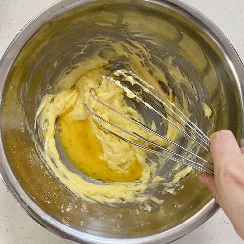 ボウルに無塩バターと粉砂糖、塩を入れ泡だて器ですりまぜる。溶きほぐした卵を少しずつ加えてよく混ぜる。