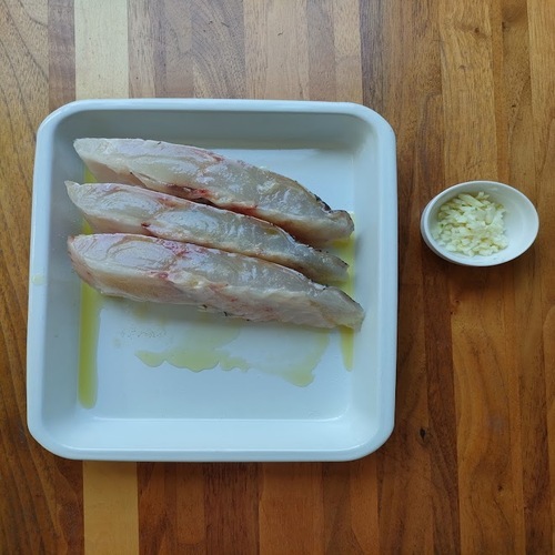 鯛に塩コショウをすりこみ、オリーブオイルを絡める。にんにくはみじん切りにする。
