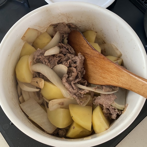 鍋を中火にかけ油を熱し、にんにく、牛肉、玉ねぎ、じゃがいもを炒める。