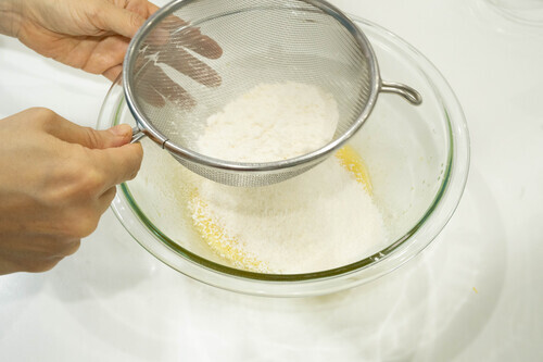 薄力粉とアーモンドプードル、ベーキングパウダーをふるい入れ、ゴムベラで切るようにして粉気がなくなるまで混ぜる。