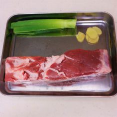 豚バラ肉を圧力鍋に入れ、しょうがスライス、ねぎ、酒、水を入れる。