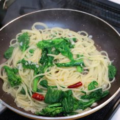 茹で上がり2分前に菜の花の茎の太い部分、1分前に柔らかい部分を加え、スパゲッティが茹で上がったら一緒にフライパンに入れる。