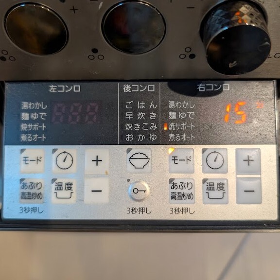 コンロにフライパンをおいて点火し、焼サポートを設定し、タイマーを15分に設定する。