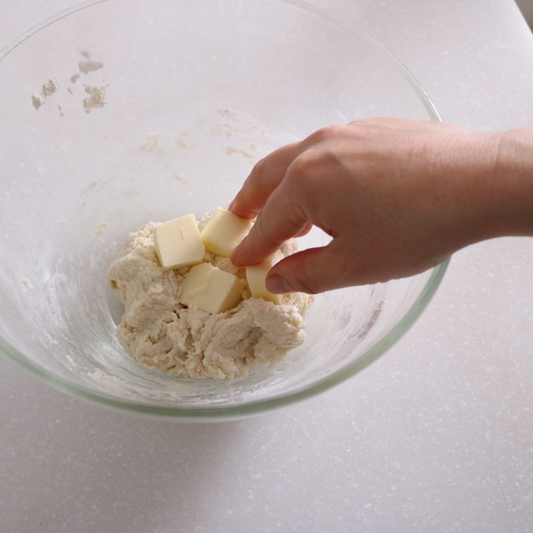 牛乳も加えて菜ばしで混ぜ、全体がまとまってきたらバターを1㎝角に切って加えて混ぜる。