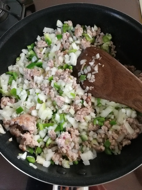 パラパラになったら玉ねぎとピーマンを入れ、しんなりするまで炒める。