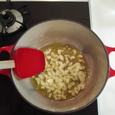 鍋にオリーブオイルとニンニクを入れ良い香りがしてくるまでゆっくりと加熱する。バゲットを加えて炒めオイルが馴染んだらパプリカパウダーを入れてパンに絡ませるように炒める。