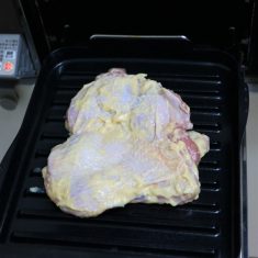 冷蔵庫から肉を出して30分程置いたら、表面の味噌ヨーグルトを少しふき取ってから皮目を上にしてマルチグリルの波型プレートに置き、「オートメニュー」「鶏もも焼き」の中火で焼く。（約20分）