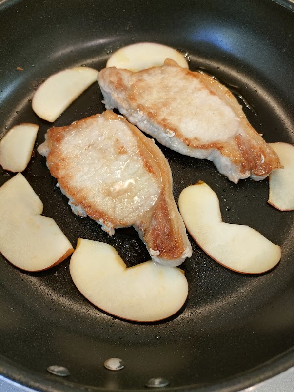 裏返しの報知が鳴ったら、肉を裏返し、薄切りにしたりんごを並べて、蓋をし、「モードキー」を押す。