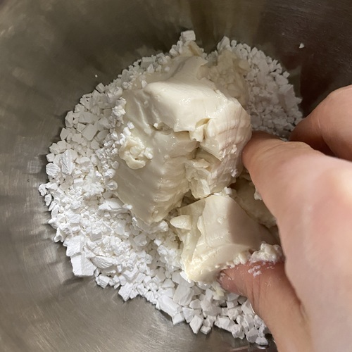 ボウルに白玉粉と絹豆腐を入れてなめらかになるまで手でよく混ぜる。耳たぶくらいの柔らかさになるように調整する。（固ければ水、やわらかければ白玉粉を加える）