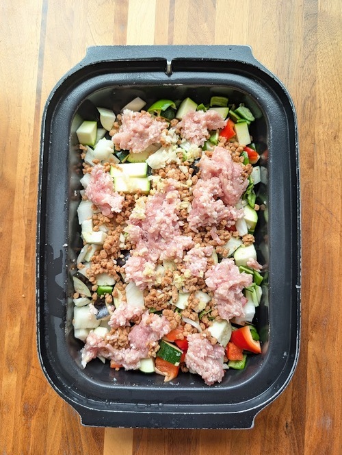 ひき肉・大豆ミート・にんにくとしょうがを広げて入れる。