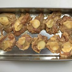 ③を冷蔵庫から出し、小麦粉と片栗粉をまぶし、もみこむ。にんにくスライスをお肉にのせ、うまく形を整えながら一切れずつバットに並べ、1時間ほど常温で馴染ませる。