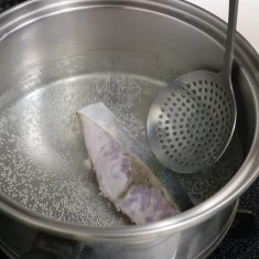 熱湯を沸かしたら火を止め、ぶりをひと切れずつ湯に入れては冷水にとって水分をふき取り、1切れを3～4個にカットする。