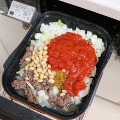 蓋を開けて肉をほぐして玉ねぎと混ぜ、そこに大豆水煮、クミンパウダー、ガラムマサラ、チリパウダー、塩を加え、トマト缶はキッチンバサミで切りながら加える。