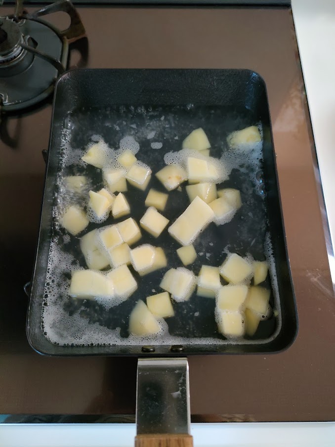 玉子焼きフライパンにじゃがいもと水を入れて火にかけ、柔らかくなるまで茹でて水けをきる。