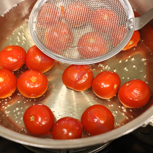 ミニトマトに十字の切り込みを入れ、沸騰した湯でさっとゆでて冷水に取り、皮をむく。