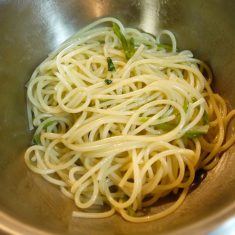 茹であがったパスタをセロリの茎と共に取り出し、オリーブオイルをからめる。
