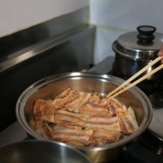 豚肉とみそを炒め、片面に火が通ったら裏返し、酒を加える。