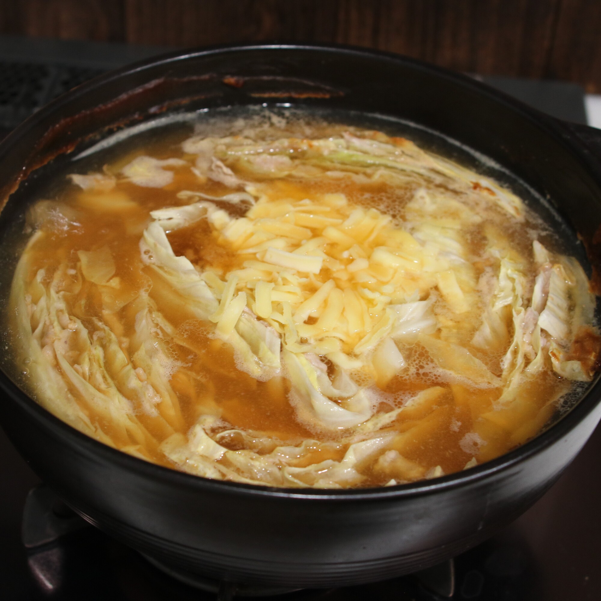 お出汁が沸騰したら中火にし、あくを取る。キャベツと豚肉に火が通ったら真ん中にシュレッドチーズを乗せ、周りの味噌を溶かし入れながらチーズに絡めていただく。
