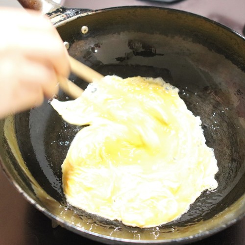 フライパンに油を入れて強火で熱する。溶いた卵を一気に入れたら手早く菜箸で混ぜ、半熟の状態でボウルに移す。