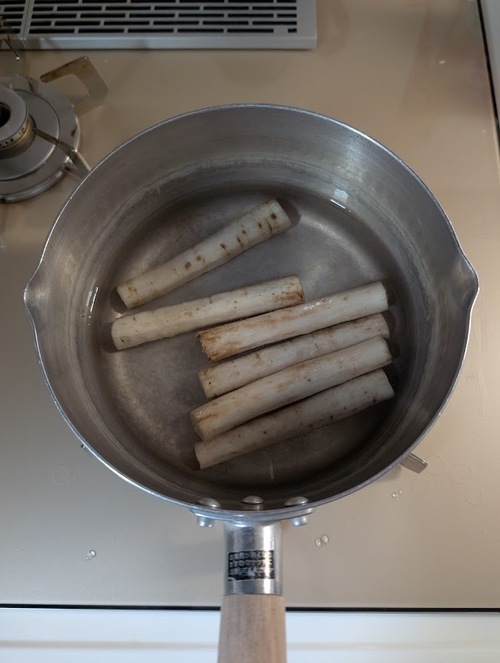 鍋にごぼうを並べ、ひたひたになるまで水を注ぎ、上面「湯沸かし・10分」かけ、茹ったらザルにあげて冷ましておく。
