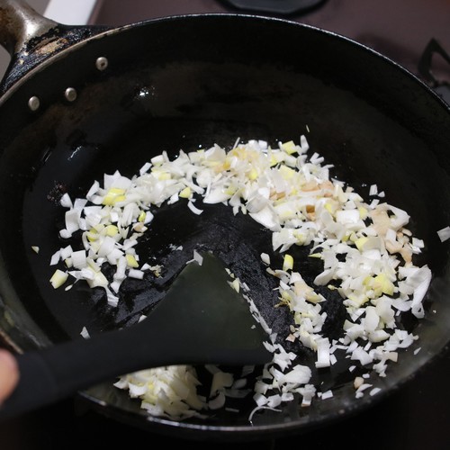 火を中火にし、ねぎ、しょうがを加えて炒め、香りがたったらトマトも加える。
